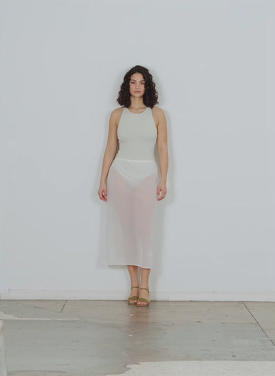 Model wearing the sheer gauze maxi pencil skirt white walking forward and turning around