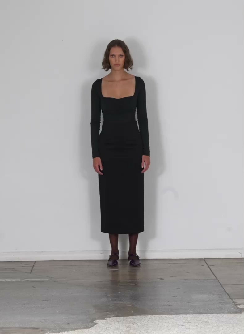 Model wearing the stretch shirred long sleeve bodysuit black walking forward and turning around