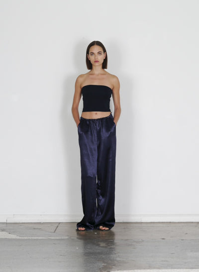 Model wearing the summer satin wide leg pullon pant dark navy walking forward and turning around