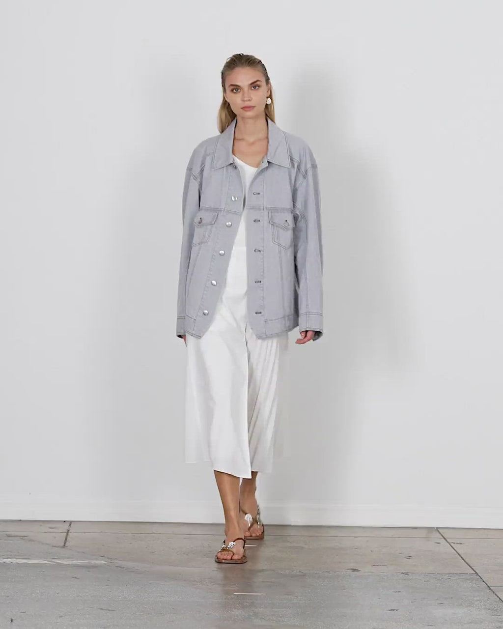 Model wearing the grey denim oversized jean jacket walking forward and turning around