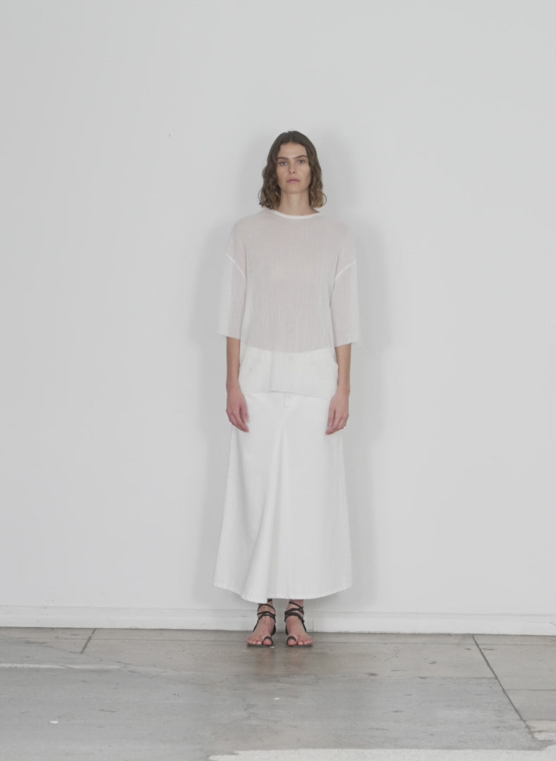 Model wearing the white denim godet midi skirt white walking forward and turning around