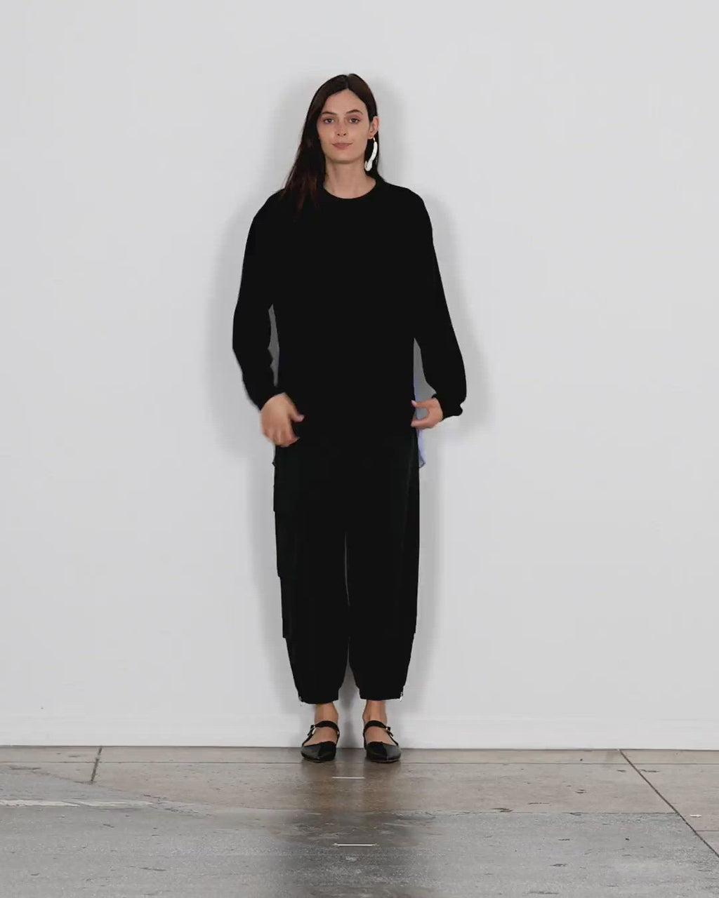 Model wearing the merino wool sweater combo pullover black multi walking forward and turning around