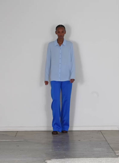 Model wearing the soft drape slim shirt light blue walking forward and turning around