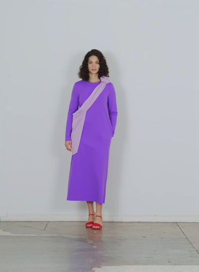 Model wearing the compact ultra stretch knit long sleeve open back d violet walking forward and turning around