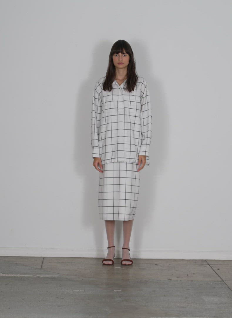 Model wearing the windowpane techy twill anorak shirt white black multi walking forward and turning around