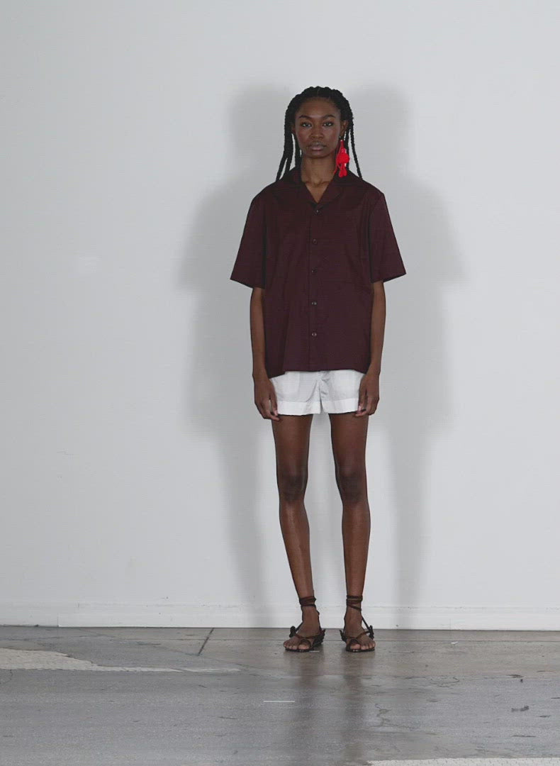 Model wearing the eco poplin camp shirt brown walking forward and turning around