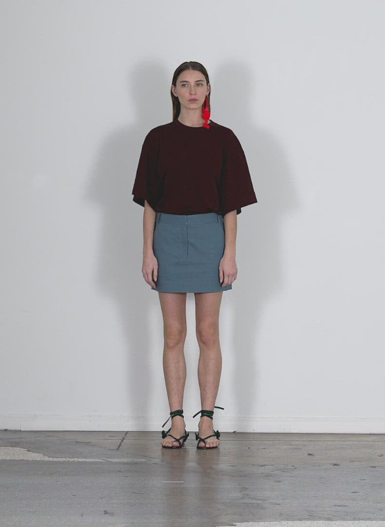 Model wearing the fluid suting mini trouser skirt walking forward and turning around