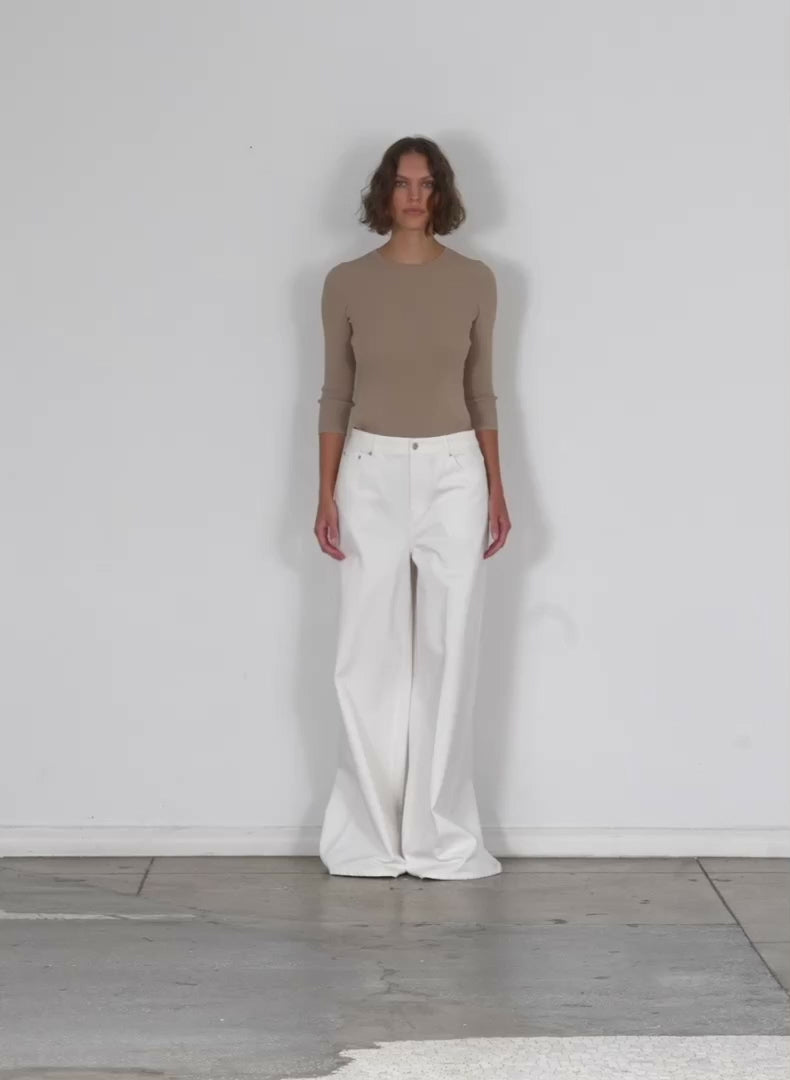 Model wearing the white denim murray jean petite white walking forward and turning around
