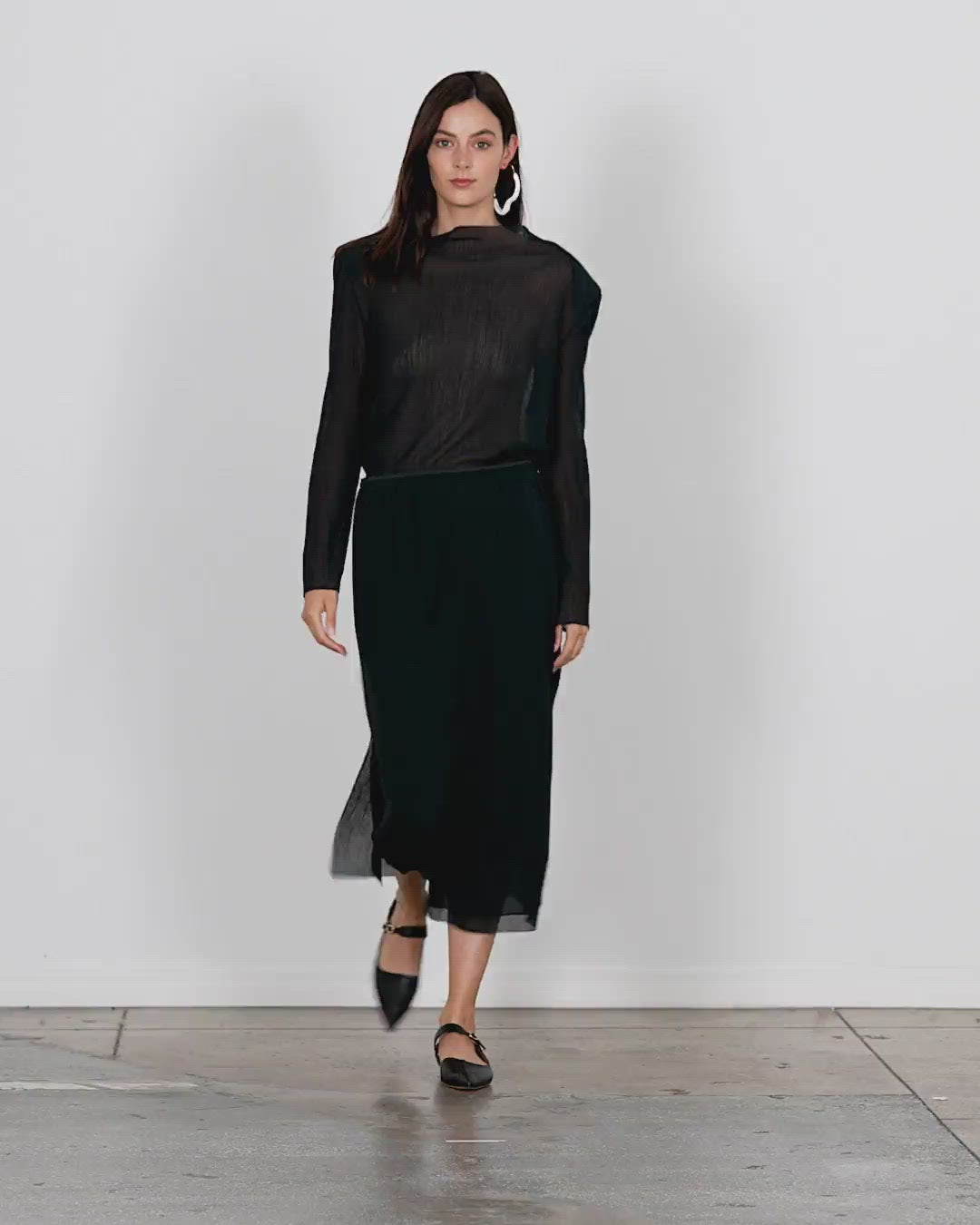 Model wearing the crepe gauze pull on skirt walking forward and turning around