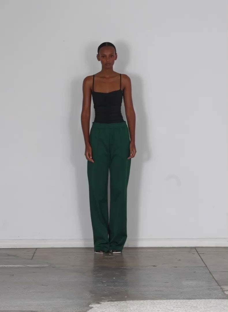 Model wearing the stretch shirred bodysuit black 1 walking forward and turning around