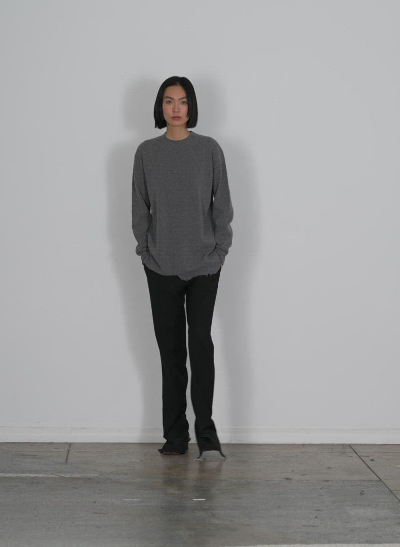 Model wearing the anna merino wool hole at back pullover heather grey walking forward and turning around