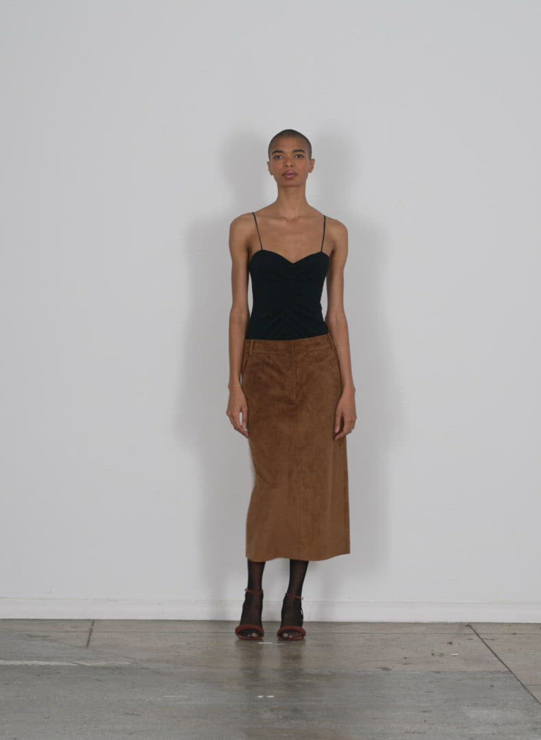 Model wearing the ultrasuede midi trouser skirt brown rust walking forward and turning around