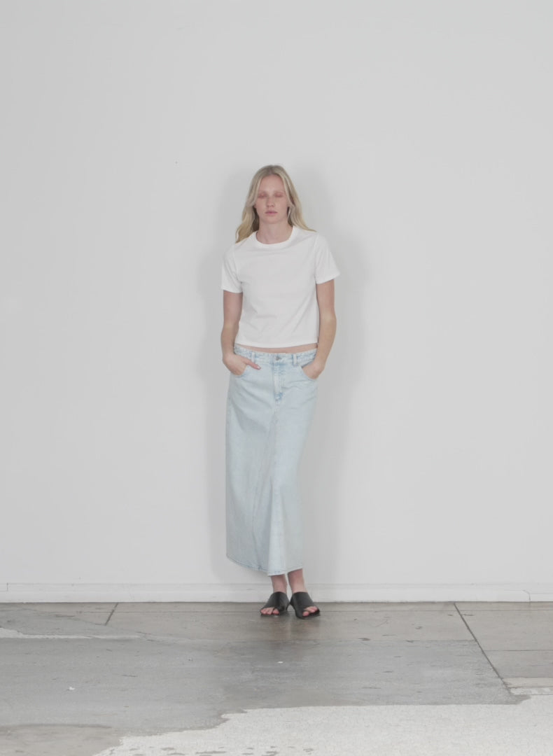 Model wearing the bleached denim godet midi skirt bleached denim walking forward and turning around