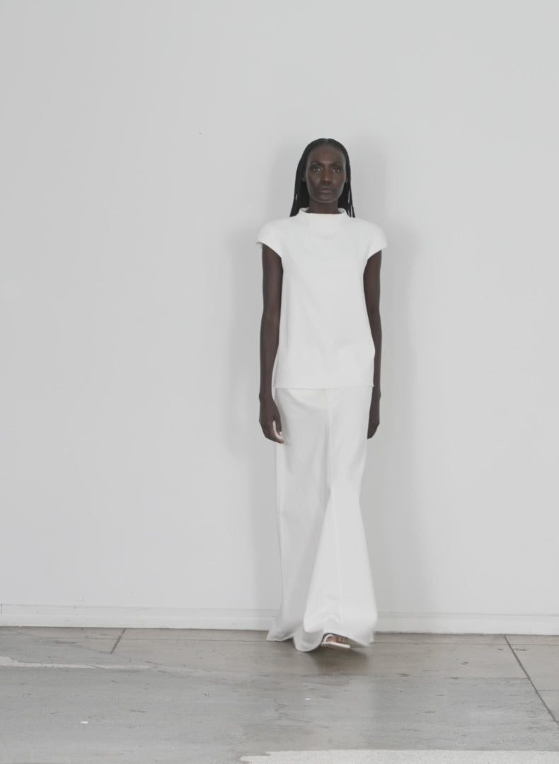 Model wearing the chalky drape funnel neck top white walking forward and turning around