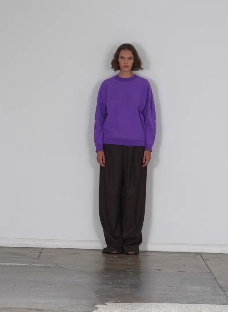Model wearing the cocoon crewneck sweatshirt purple walking forward and turning around