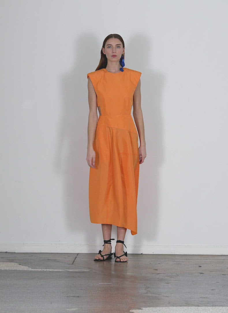 Model wearing the italian sporty nylon sleeveless balloon dress orange walking forward and turning around