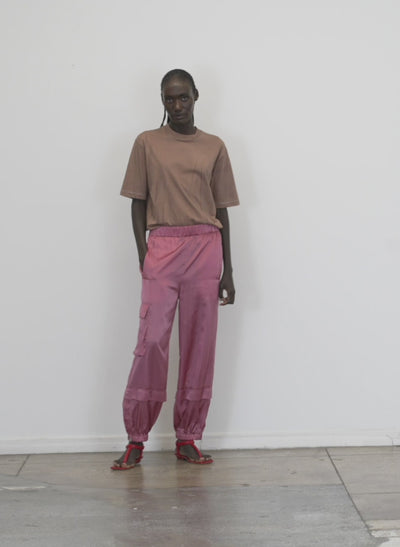 Model wearing the shiny nylon wilt pull on jogger rose walking forward and turning around