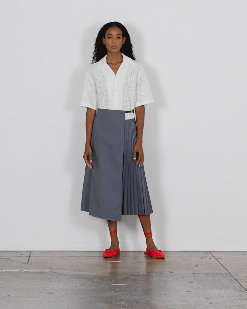 Model wearing the pleated cotton leather waist belt wrap skirt walking forward and turning around