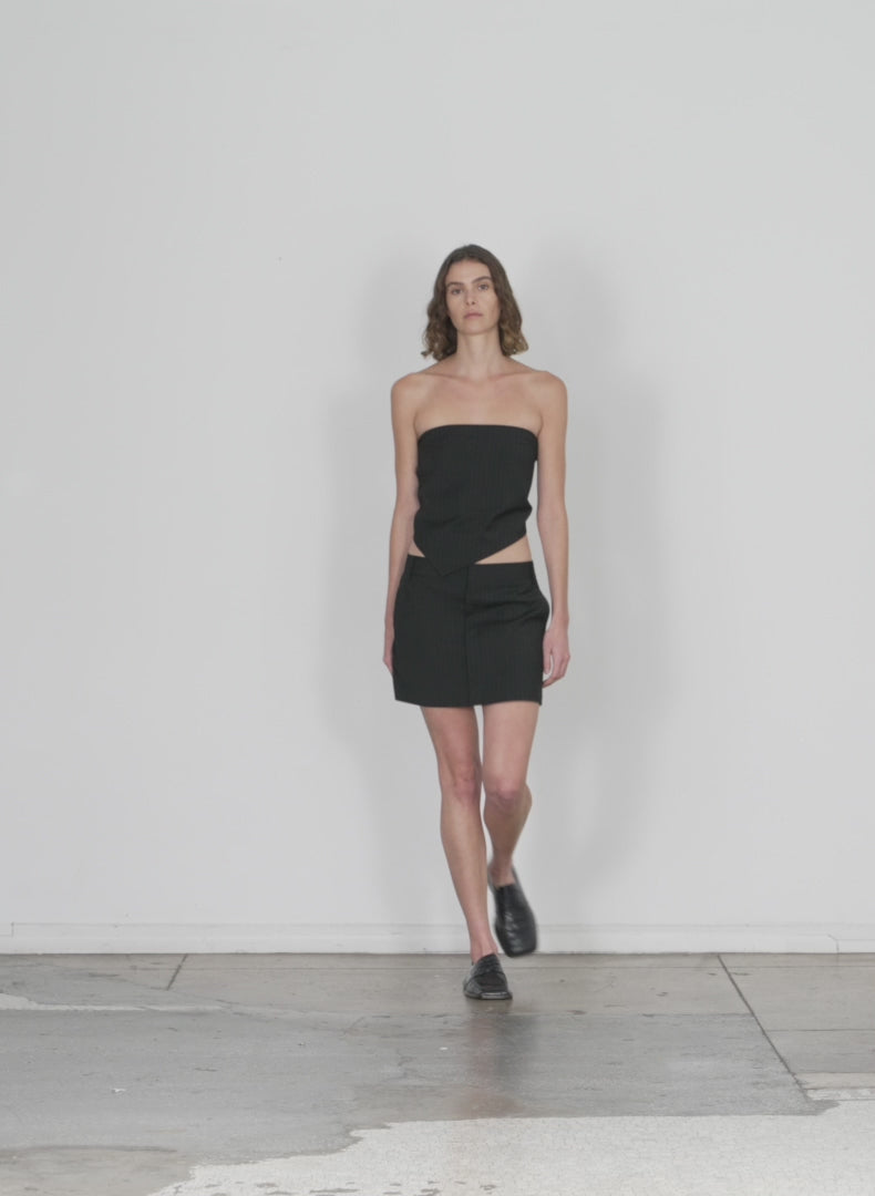 Model wearing the dominic pintstripe skirt black white multi walking forward and turning around