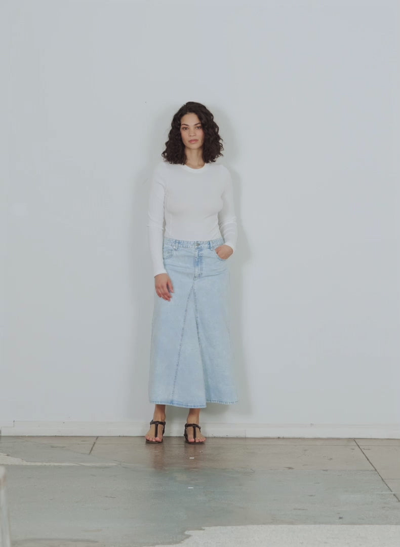 Model wearing the bleached denim godet midi skirt bleached denim walking forward and turning around