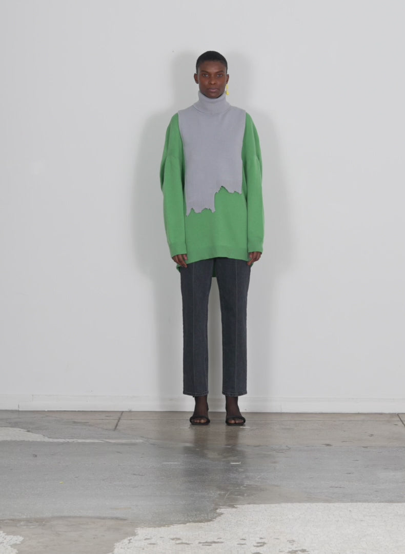 Model wearing the airy extrafine wool circular origami pullover powdery green walking forward and turning around