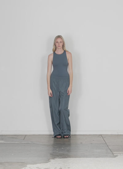 Model wearing the italian sporty nylon wide leg pullon pant blue grey walking forward and turning around