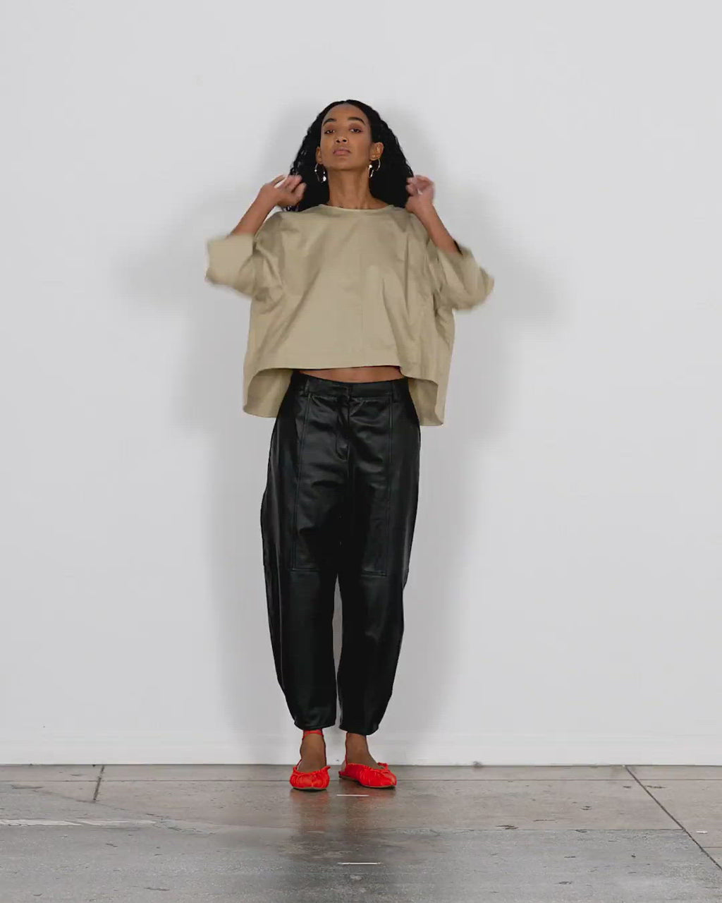 Model wearing the eco poplin sculpted top 1 walking forward and turning around